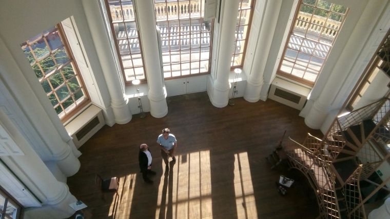 Looking down inside the Radcliff Observatory building at two people talking