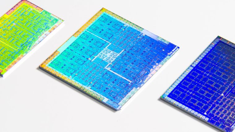 Three colourful GPUs with their packaging removed lying on a white surface