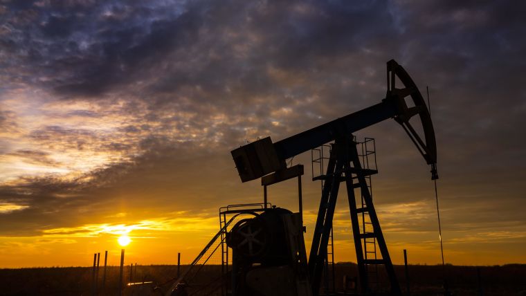 Fossil fuel extraction in a remote field, with equipment silhouetted against a grey sunset

Source: Calin Tatu\Shutterstock.com